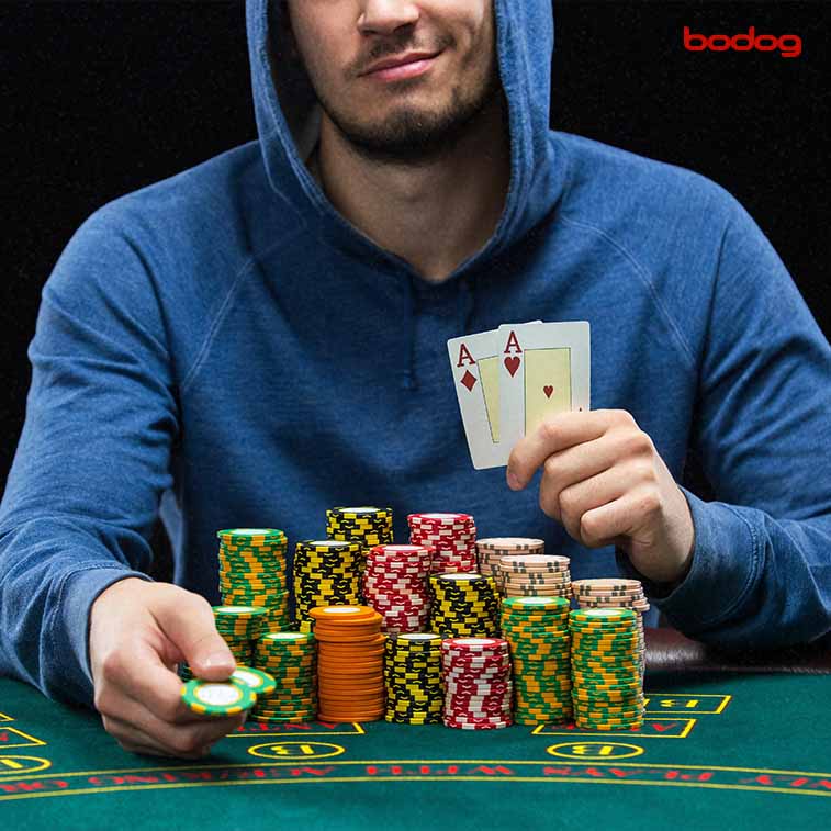 cartas en mano y fichas de poker